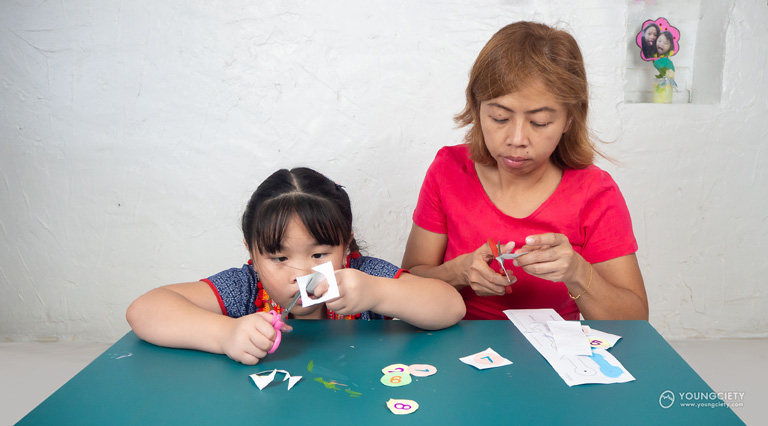 เด็กและผู้ปกครองช่วยกันตัดกระดาษ