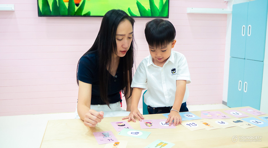 ผู้ปกครองกำลังสอนเด็กอ่านบัตรคำพยัญชนะไทยตัว ฑ